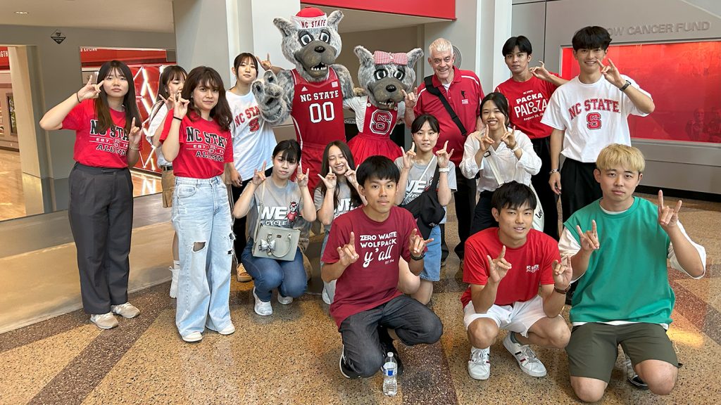 students in front of Mr. and Ms. Wuf statues